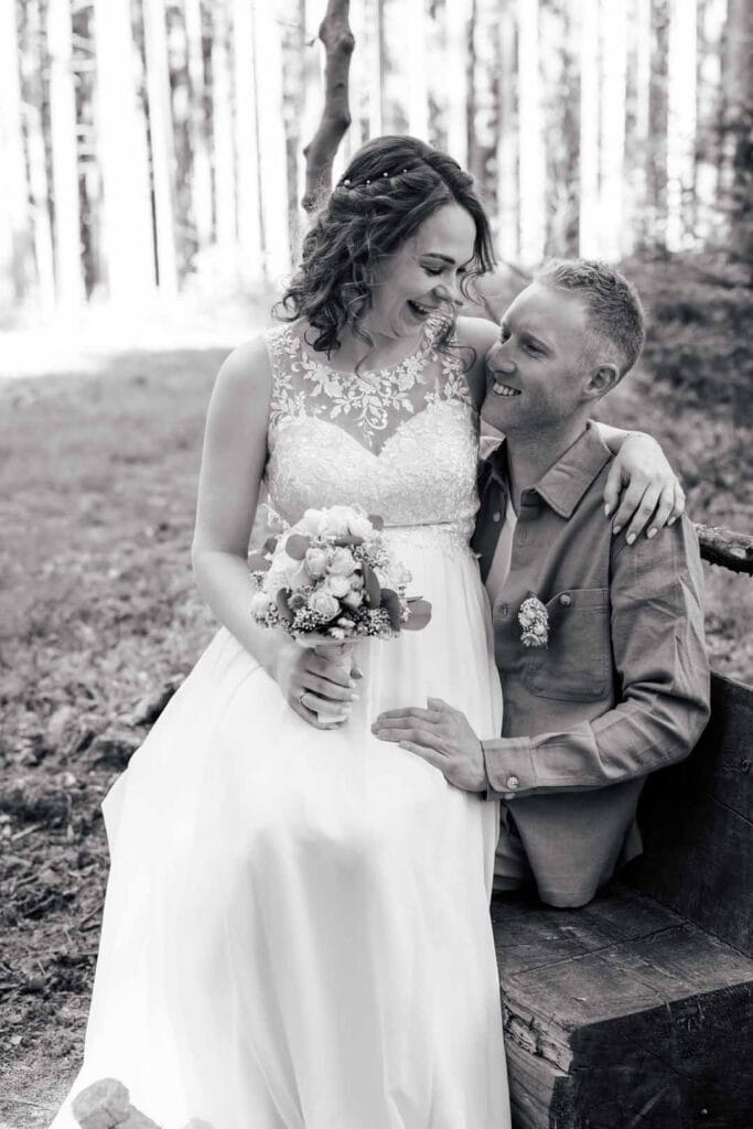 Hochzeitspaar im Wald, lachend und verliebt, natürliche Hochzeitsfotos im Freien.