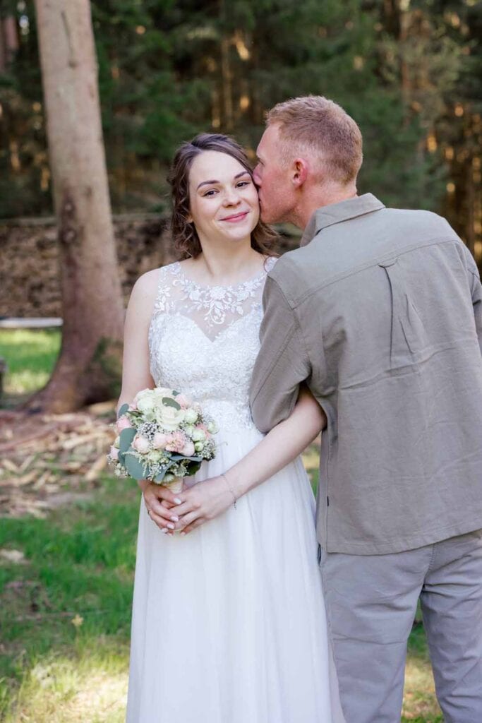 Brautpaar im Wald, romantisches Hochzeitsfoto, emotional, natürlich, authentisch.