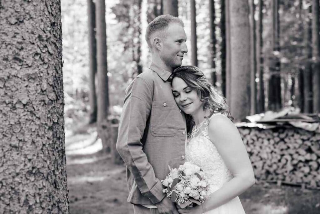 Brautpaar im Wald bei Sonnenlicht, romantisches Hochzeitsfoto.