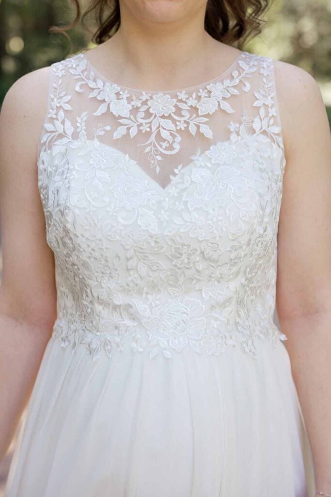 Hochzeitsbraut in eleganter Spitze, Nahaufnahme, mit Fokus auf das detaillierte Brautkleid.