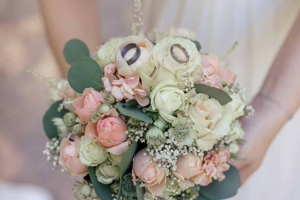 Eleganter Hochzeitsblumenstrauß mit Eheringen, romantisch und zart.