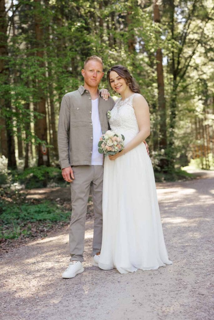 Brautpaar im Wald bei Sonnenlicht, natürliche Hochzeitsfotografie.