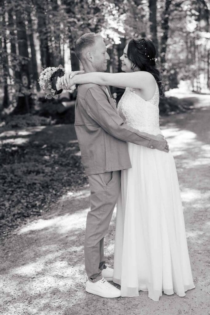 Hochzeitspaar umarmt sich im Wald, emotionale Hochzeitsfotografie im Freien.