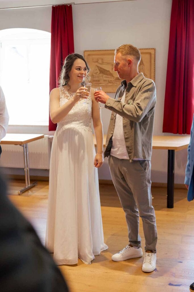 Braut und Bräutigam beim Anstoßen bei ihrer Hochzeit, glückliche Momente.