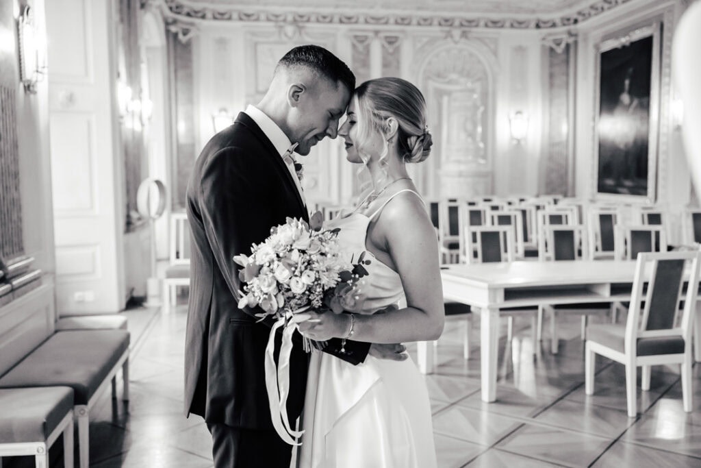 Braut und Bräutigam in Liebe in einem eleganten Saal.