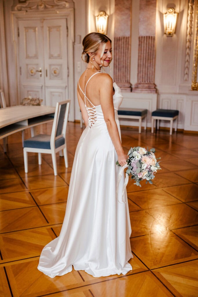 Braut in weißem Kleid mit Blumenstrauß, fotografiert von Saskia Römer – Fotografie mit Herz Lauingen.