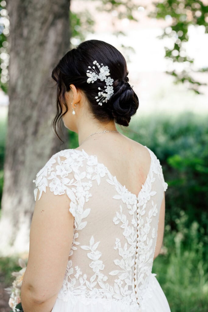 Braut mit eleganter Hochzeitsfrisur und Blumenaccessoire.