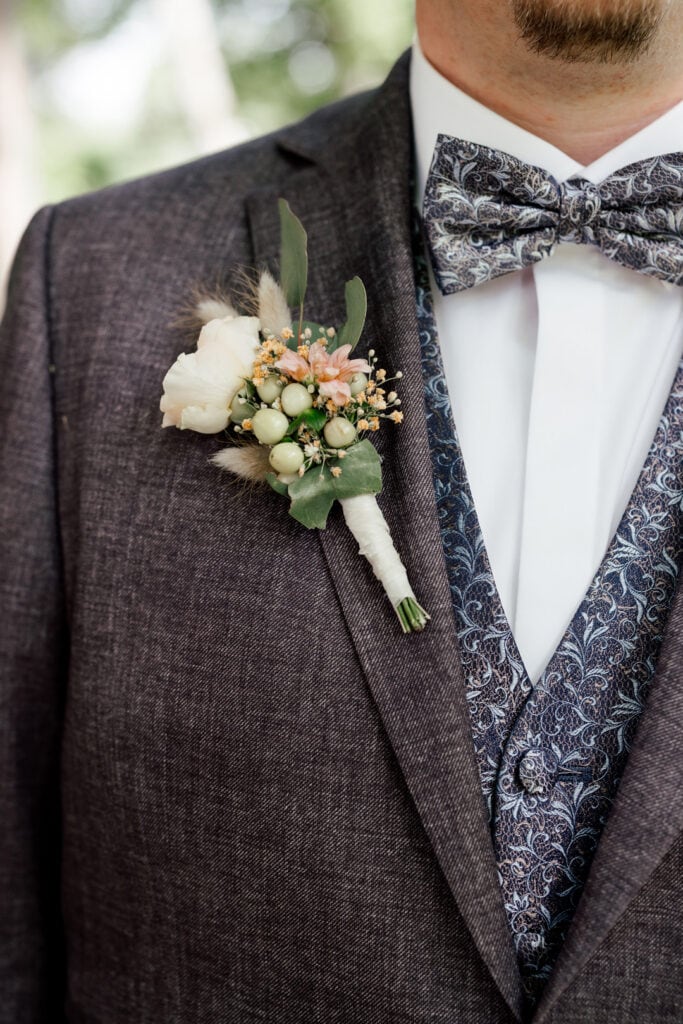 Hochzeitsanzug mit Blumen, fotografiert von Saskia Römer – Fotografie mit Herz Lauingen.