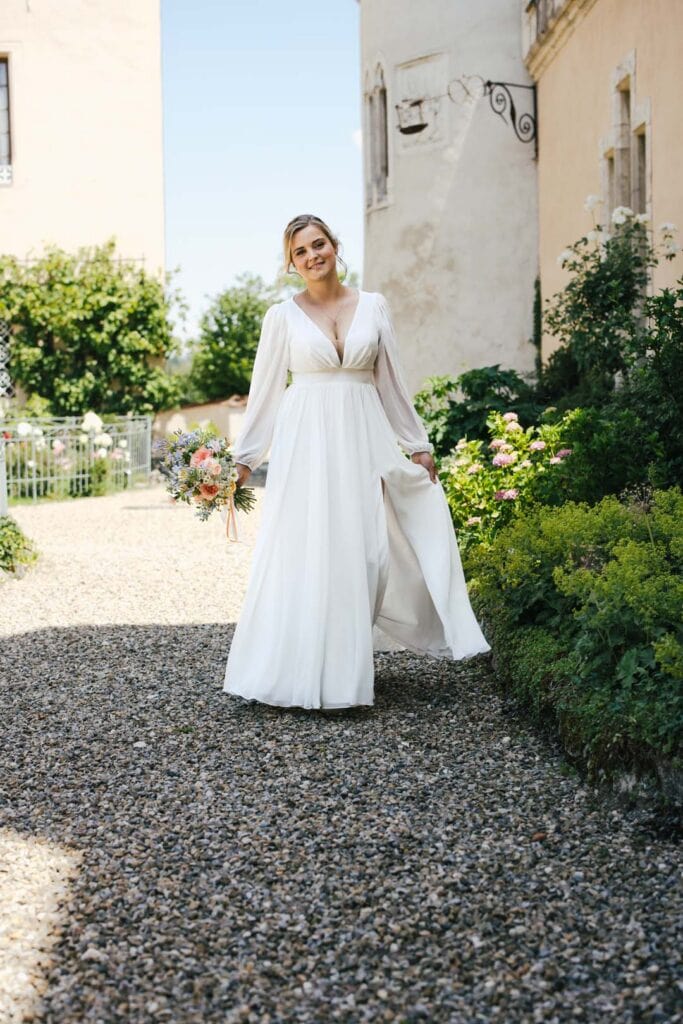 Braut in weißem Kleid mit Blumenstrauß vor alten Gebäuden in Lauingen.
