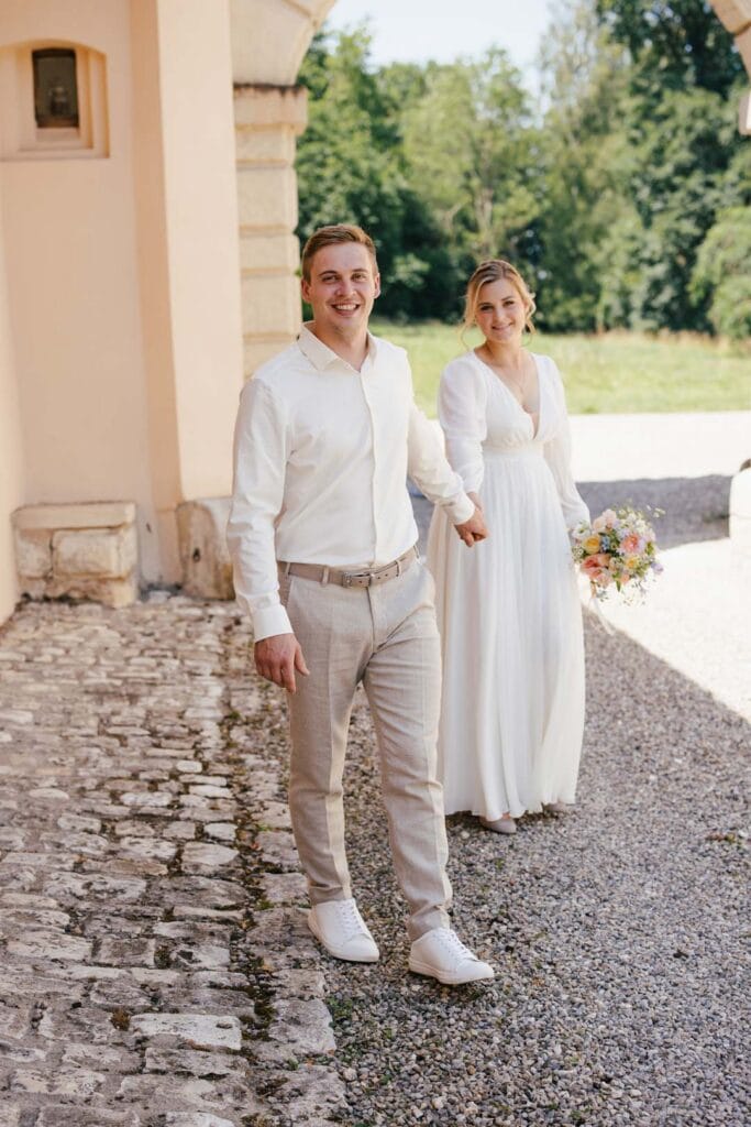 Hochzeitspaar in Weiß vor historischem Gebäude in Lauingen.
