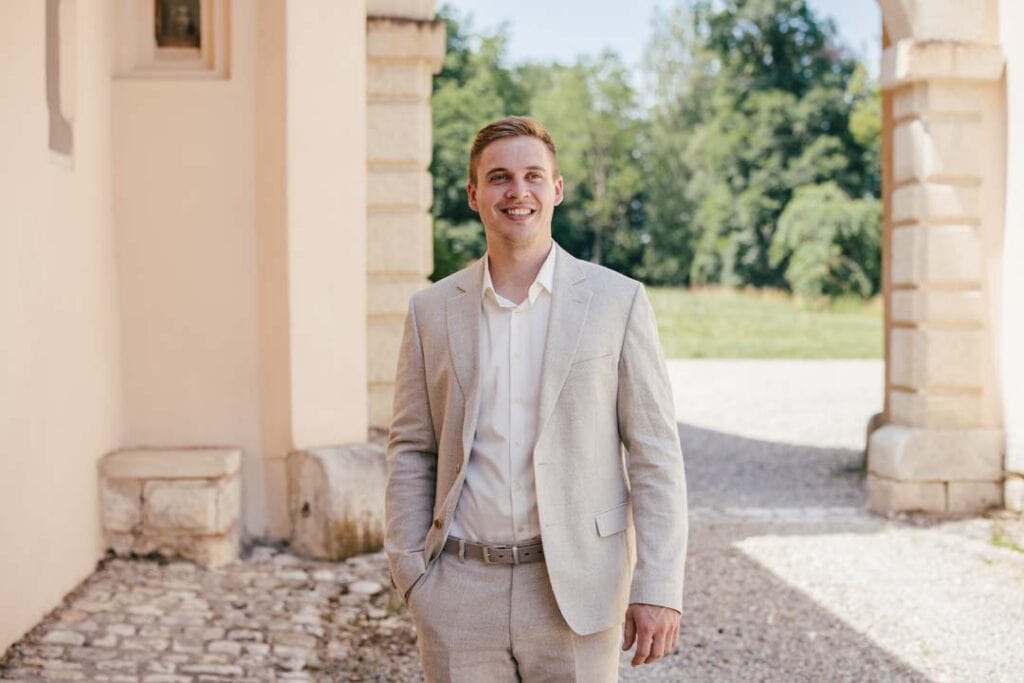 Junger Mann in hellem Anzug vor historischen Gebäuden in Lauingen.